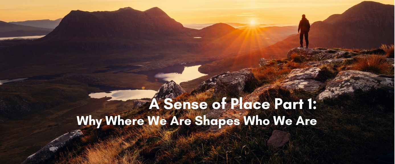 A silhouetted hiker stands on a rocky outcrop overlooking a mountain valley with lakes at golden hour, with the text A Sense of Place Part 1: Why Where We Are Shapes Who We Are