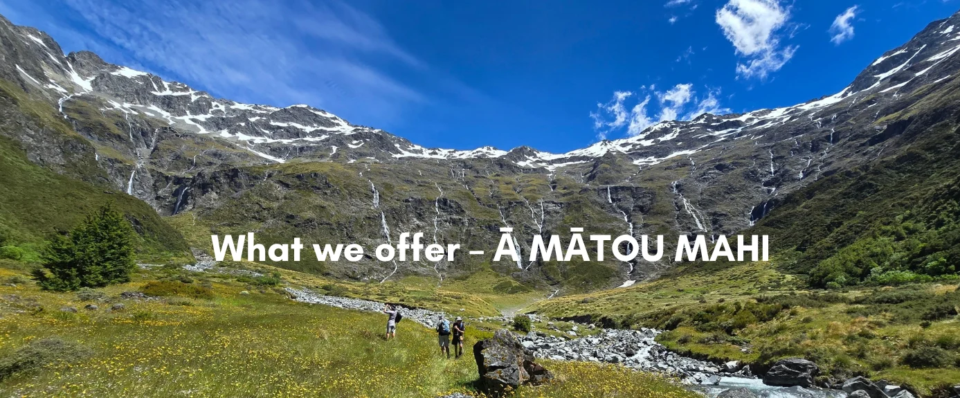 Banner image of a glacier-carved alpine valley with waterfalls cascading down mountain walls, hikers walking a trail through wildflowers, and the text "What we offer – Ā MĀTOU MAHI."